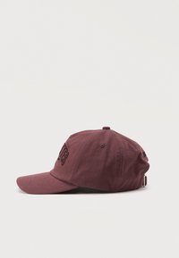 Casquette de baseball bordeaux foncé avec texte brodé en noir et sangle métallique réglable sur fond blanc uni.