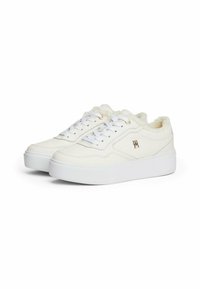 Sneakers bianchi con tomaia in pelle liscia, interno morbido e peloso, occhielli dorati e suola platform, caratterizzati da un logo discreto sul lato.