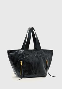 Μαύρη δερμάτινη τσάντα ώμου με δύο εμπρόσθιες τσέπες με φερμουάρ και διπλούς ιμάντες ώμου σε απλό γκρι ανοιχτό φόντο.