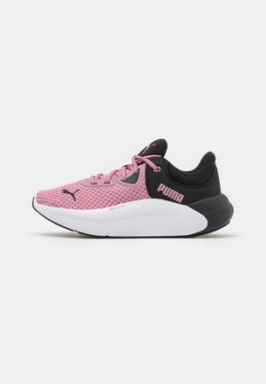 Zapatillas deportivas en rosa y negro con parte superior de malla, cuello acolchado y entresuela blanca. Presentan un logotipo sutil y acentos texturizados en la suela exterior.