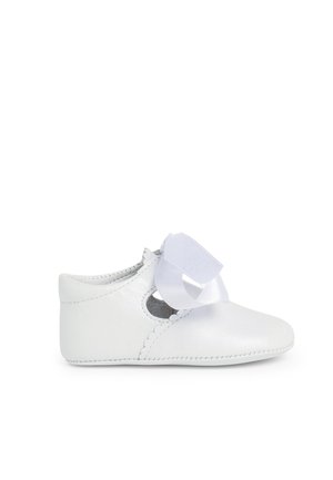 Scarpina bianca in pelle per bambino con lati intagliati, bordi decorativi a scallop e un dettaglio di nastro bianco sulla parte anteriore. Texture liscia, punta rotonda.