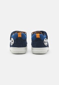 Marineblå sneakers med en ruskindsfinish, mesh-detaljer, orange hælkappe og en fodbolddetalje på siden; hvid gummisål.