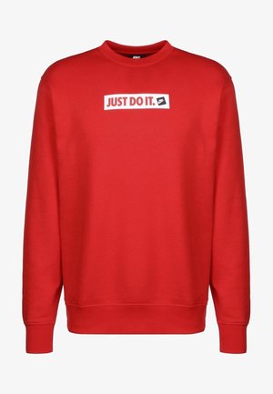 Sudadera roja con cuello redondo, que presenta un panel rectangular blanco y texto negro que dice "JUST DO IT." Tela suave y texturizada.