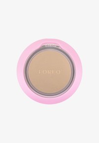 Ronde cosmetische compact met een doorzichtige deksel. Lichtgouden poeder binnenin, omringd door een zachte roze behuizing. Gegraveerd "FOREO" logo op de bovenkant.