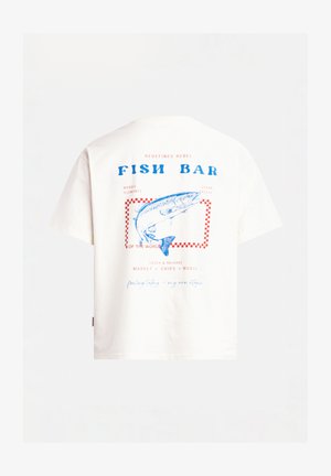T-shirt en coton blanc avec un graphisme de poisson bleu, bordure à carreaux rouges, et le texte "FISH BAR" au dos. Manches courtes, coupe décontractée.