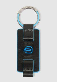 Llavero de cuero negro con detalles en azul, cuerpo rectangular y anillo metálico circular. Presenta un logo en relieve de color azul en el frente.