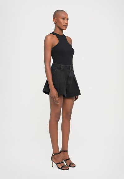 Black sleeveless bodysuit paired with high-waisted black denim shorts. The shorts feature pleats and a fitted waist, complemented by strappy black heels.