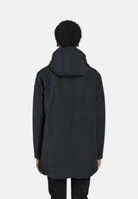 Giacca impermeabile blu scuro con cappuccio, dotata di maniche lunghe, schiena leggermente allungata e una texture liscia e opaca.