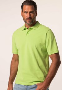 Zelené polo tričko vyrobené z bavlny s krátkým rukávem, límečkem a třemi knoflíky. Disponuje hladkou texturou a uvolněným střihem.
