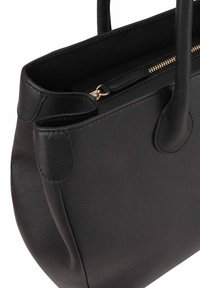 Zwarte leren tote bag met een gladde textuur, een ritssluiting aan de bovenkant en dubbele handvatten. Beschikt over afgeronde hoeken en subtiele stiksels.