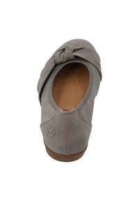 Chaussure en suède gris avec un accent noué au niveau de l'orteil et une ouverture arrondie. La semelle intérieure présente des perforations pour une meilleure respirabilité.