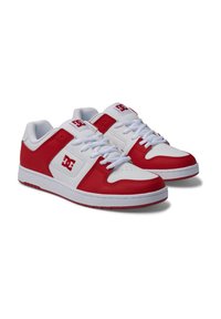 Zapatillas deportivas rojas y blancas con parte superior de cuero suave, puntera perforada, cordones planos y un logotipo en el costado y la lengüeta.