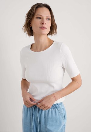 White ribbed short-sleeve top with a round neckline, paired with light blue drawstring pants. Smooth texture, fitted design.