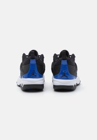 Černé a modré sportovní boty s texturovaným svrškem, polstrovaným límcem a bílými mezipodešvemi. Obsahují ikonické logo na patě a kontrastní podešev.
