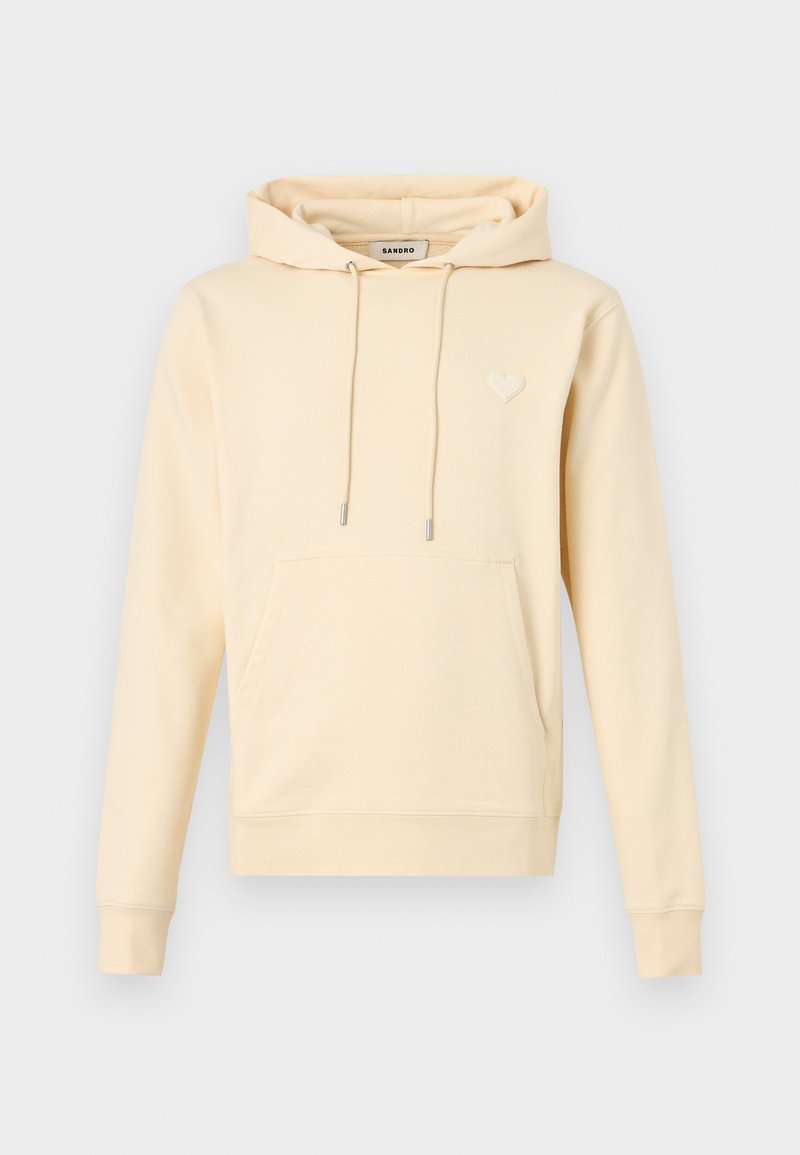 Beige hooded sweatshirt with front pouch pocket, drawstring hood, ribbed cuffs, and a small heart emblem on the left chest.