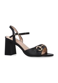 Schwarze Leder-Sandalen mit Absatz, offen an der Zehe und verstellbarem Knöchelriemen. Mit goldfarbener Hardware-Details auf der Vorderseite.