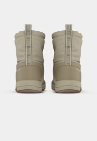 Beige enkellaarsjes met een zachte bovenkant, voorzien van een gevoerde kraag, een duale textuur zool en een opvallend merklogo op de achtertab.