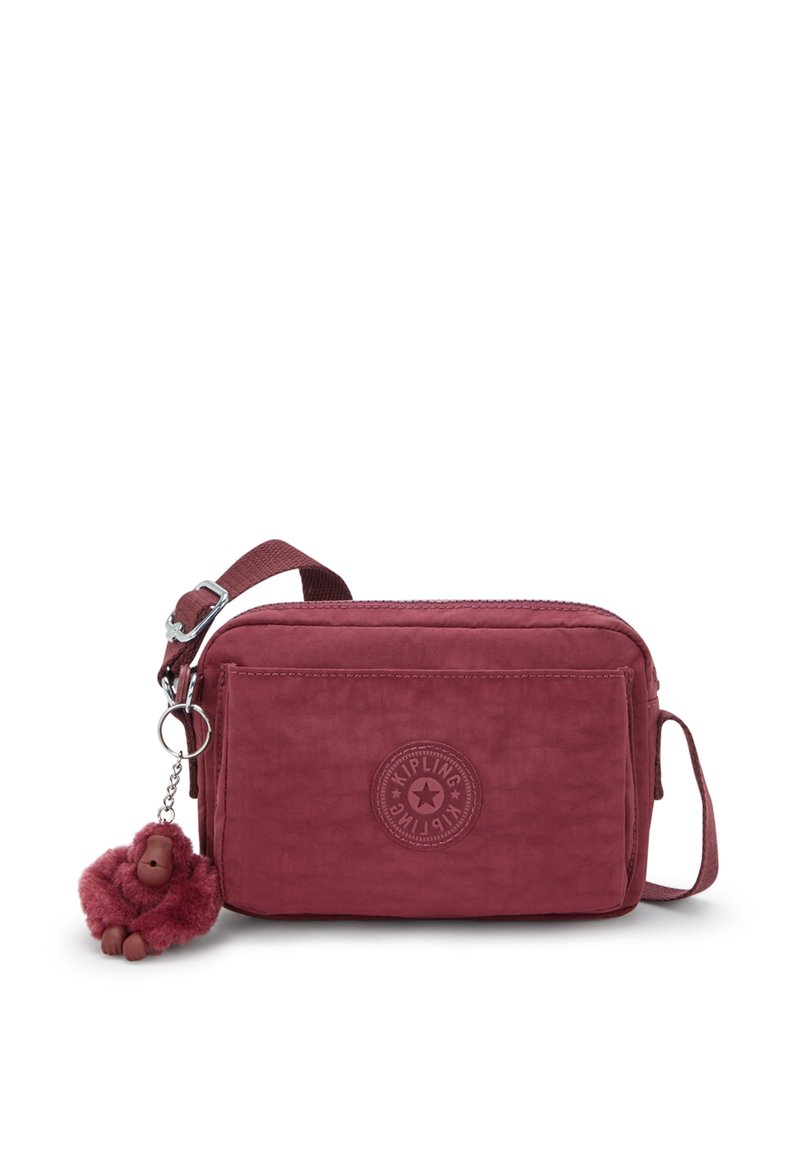 Rød stof crossbody taske med en struktureret overflade, justerbar rem, cirkulært logo og en aftagelig pelsabe charme.