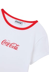 T-shirt bianco con colletto rosso a coste, caratterizzato dalla scritta "Enjoy Coca-Cola" in rosso corsivo sul davanti. Tessuto in cotone, maniche corte.