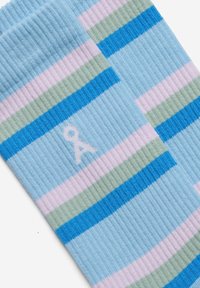 Calzini azzurro chiaro a coste con strisce orizzontali rosa, verde e blu e un accento logo bianco su un lato.