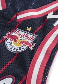 Red Bull Salzburg sports trøje i mørkeblå mesh-stof, med røde og hvide striber, samt et logo med to røde tyre og en gul fodbold.