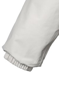 Hvid jakkesælesk læg med samlet elastisk manchette, glat tekstur og et simpelt, tapered design. Ingen synlige mønstre eller hardware detaljer.