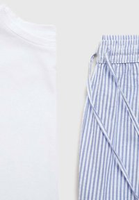 White cotton t-shirt alongside blue and white striped drawstring pants, featuring a soft texture and relaxed fit.
