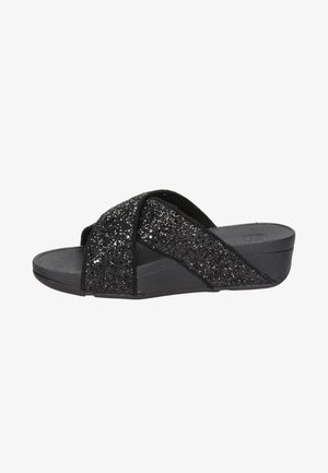 Czarne klapki z krzyżującymi się paskami o błyszczącej fakturze. Płaska podeszwa z niewielkim obcasem, wykonane z materiałów syntetycznych.