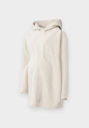 Fleece zip-up hoodie in off-white, featuring a hood, long sleeves, and two side pockets. Soft texture with a relaxed, oversized fit.