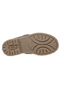 Suela de calzado marrón con un diseño de goma texturizada, que presenta ranuras para tracción, nombre de la marca embossado y marcas de tamaño.