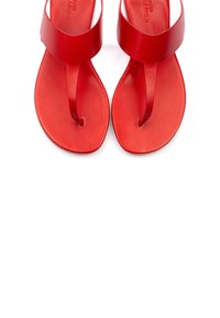 Sandali rossi con un design minimalista, suola piatta, cinturino per le dita e una banda superiore ampia. Realizzati in materiale liscio e lucido.
