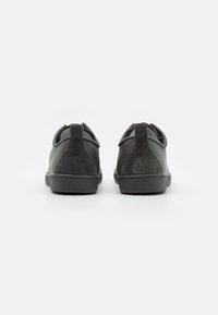 Scarpe nere con finitura in pelle liscia e suede. Punta arrotondata, design a caviglia bassa e tacco sottile. Anello posteriore per una facile indossabilità.