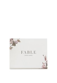 Bijela pravokutna ambalaža s cvjetnim detaljima u ružičastoj i zelenoj boji, s natpisom "FABLE ENGLAND" ispisanim elegantnim fontom.