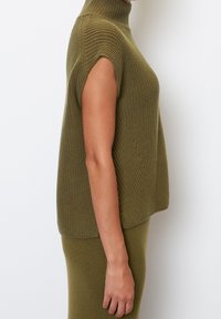 Ærmeløs, strikket sweater i olivengrøn med høj hals. Har et struktureret mønster og en afslappet pasform. Færdig med ribkant.