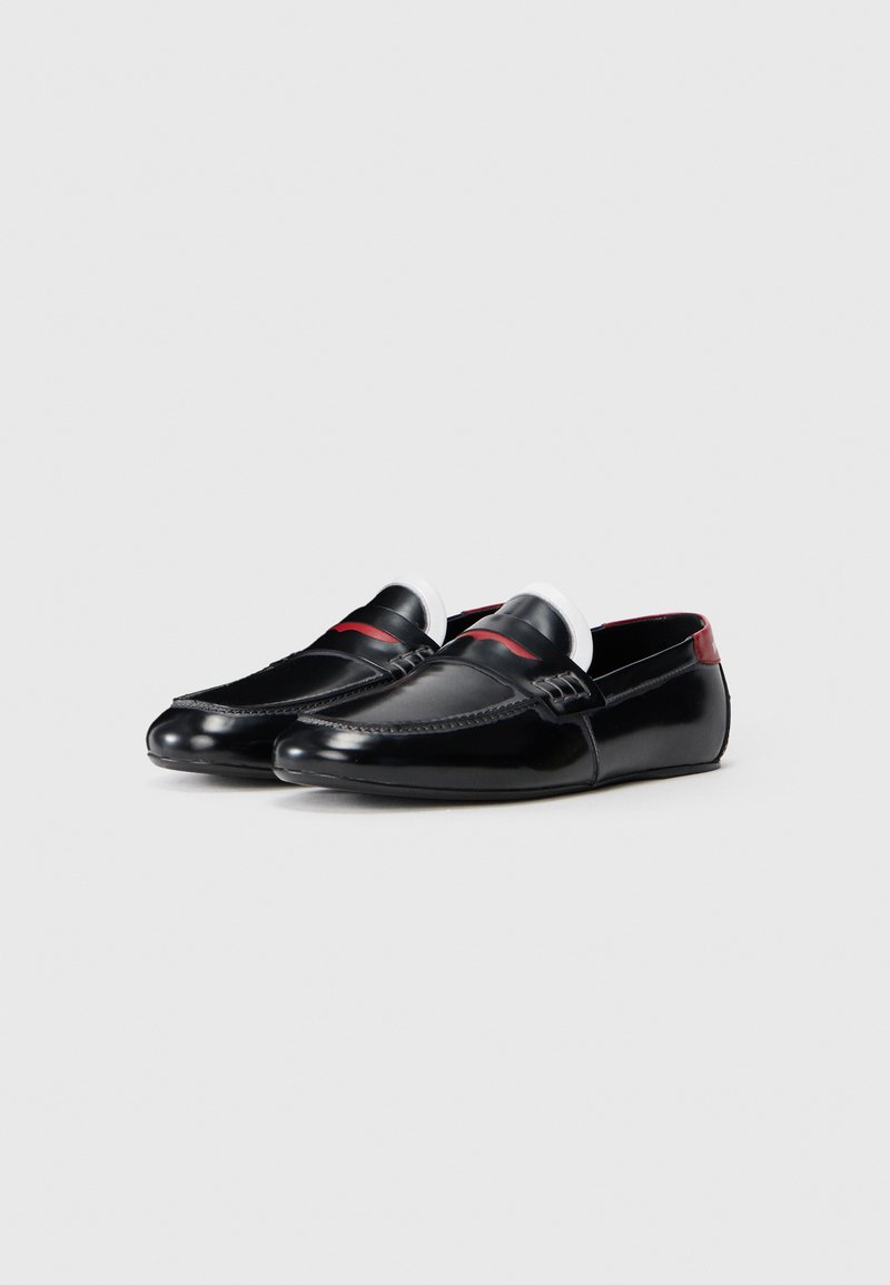 Sorte læder loafers med en glat finish, kontrasterende røde detaljer og detaljeret syning langs kanterne. Lavprofil design med slip-on stil.