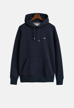 Navy blue hooded sweatshirt made of soft fabric with a front pocket, drawstrings, and a small logo on the chest. Smooth texture.