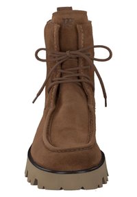 Brune ruskinds ankelstøvle med snørebånd fortil, polstret krave og chunky beige sål. Har et logo på tungen og syninger som dekorative detaljer.
