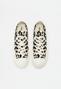 Zapatillas de lona con estampado de leopardo en beige, negro y rosa, con cordones blancos, punta redondeada y suela de goma. Ojetes plateados realzan el diseño.