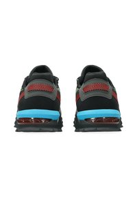 Des chaussures de sport noires avec des accents gris, des motifs rouges et verts sur les côtés, et une semelle intermédiaire bleue. Talon rembourré pour le soutien et la traction.