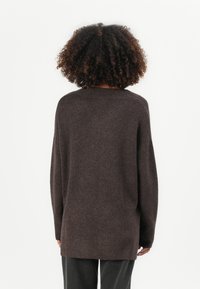 Maglione marrone lavorato a maglia con una vestibilità rilassata, scollatura rotonda e spalle cadenti. Tessuto morbido e maniche lunghe, che si estendono oltre i fianchi.