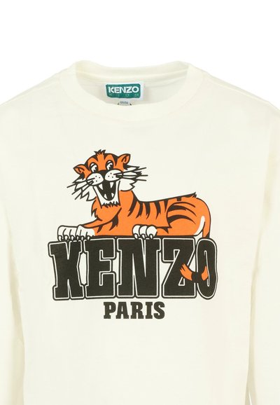 T-shirt bianca a maniche lunghe con una vivace grafica di una tigre arancione e nera e un testo in grassetto che recita "KENZO PARIS" in nero. Materiale in cotone morbido.