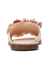 Infradito rosa chiaro con suola piatta, tomaia in tessuto testurizzato con frange decorative e dettagli arrotondati, arricchita da perline.