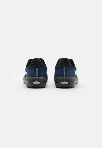 Blue suede and mesh skate shoes with black accents, cushioned collar, white stitching, and rubber outsole featuring logo detail.