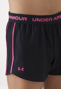 Juodi sportiniai šortai su rožiniais akcentais, su elastingu juosmeniu ir "Under Armour" logotipu, taip pat kontrastingomis šoninėmis juostomis. Textūruota medžiaga.