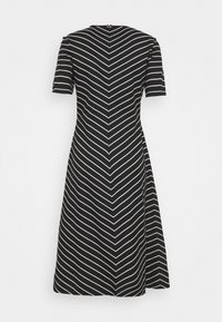 Schwarzes Kleid mit kurzen Ärmeln, das ein Zickzackmuster in weißen Streifen aufweist, knielang ist und einen Reißverschluss auf der Rückseite hat. Glatte Textur.