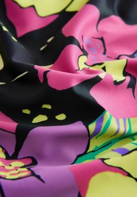 Pestrá látka s výraznými květinovými vzory. Převážně černý základ s růžovými, žlutými a zelenými akcenty, hladká textura.