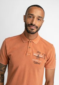 Petrol Industries SPORTY ARTWORK - Polo shirt - desert orange