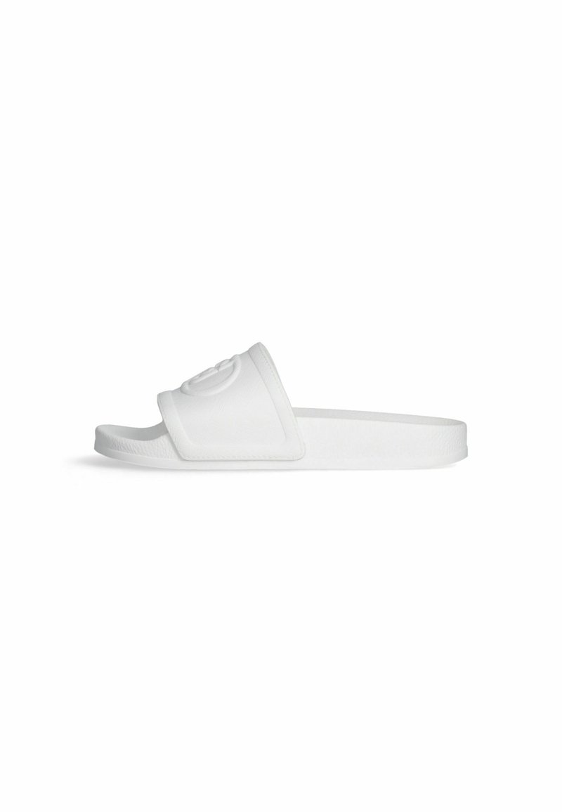 White slide sandal featuring a textured strap with a prominent embossed logo, a flat sole, and a minimalist design.