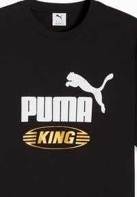 Black cotton T-shirt featuring a white leaping puma logo, bold white "PUMA" text, and "KING" in gold within an oval graphic.