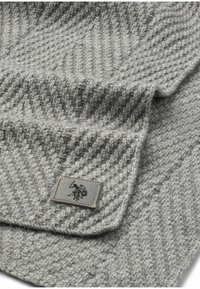 Grå strikket tørklæde med et tekstureret zigzag-mønster og et broderet logo-patch. Blødt materiale med et varmt, hyggeligt udseende.